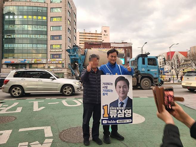 Ryu Sam-young, former police superintendent, poses for a photo with a supporter near Isu Station on Tuesday. (Jung Min-kyung/ The Korea Herald)