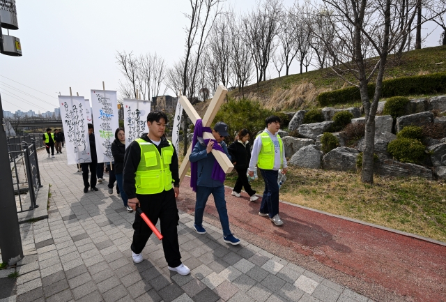 워십퍼스무브먼트가 주최한 '크로스 로드' 참가자들이 27일 경기도 김포 일대에서 십자가를 지고 걸으며 예수님 고난을 묵상하고 있다. 김포=신석현 포토그래퍼
