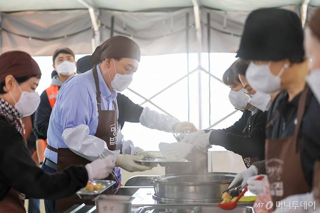 [서울=뉴시스] 윤석열 대통령이 27일 서울 명동성당 내 무료 급식소인 명동밥집을 찾아 배식 봉사활동을 하고 있다. (사진=대통령실 제공) 2024.03.27. photo@newsis.com *재판매 및 DB 금지 /사진=전신