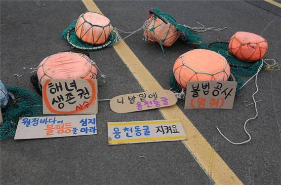 ▲재난피해를 전가하는 하수종말처리장 증설을 반대하는 월정리 해녀들이 그들의 태왁을 바당이 아닌 길바닥에 놓았다. 용천동굴이란 말이 자주 등장하는 것은 현재의 월정리 제주동부하수처리장이 용천동굴 보호지역과 겹치기 떄문이다. 용천동굴 하류 호수구간 일부는 세계자연유산 보고에 누락되었다. 월정리 해녀들은 자신들의 투쟁을 "미래를 위한 싸움"이라고 했다. ⓒ엄문희