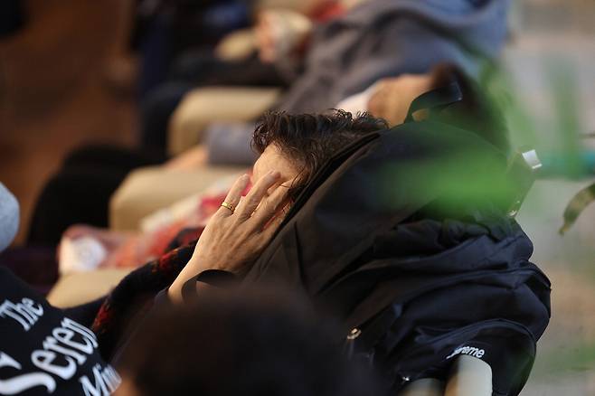 의료 대란이 장기화하고 있는 가운데 28일 서울의 한 대학병원에서 외래 환자가 진료 순서를 기다리다 지쳐 잠들어 있다.  연합뉴스