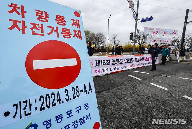 [서울=뉴시스] 정병혁 기자 = 여의도봄꽃축제 개막을 하루 앞둔 28일 서울 영등포구 여의서로에서 작업자들이 차량통제 바리케이트와 안내판을 설치하고 있다. 영등포구는 29일부터 오는 4월 2일까지 여의서로 국회뒷편 일대에서 영등포 여의도봄꽃축제를 개최한다. 2024.03.28. jhope@newsis.com