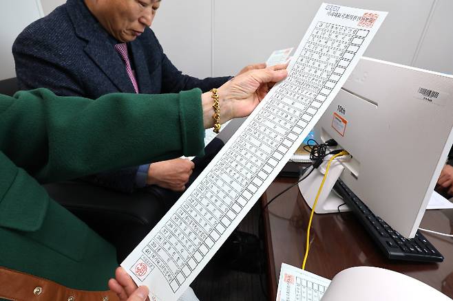 제22대 국회의원 선거를 14일 앞둔 27일 오전 인천시 미추홀구 선거관리위원회에서 정당추천위원들이 인쇄된 거소자 투표용지를 확인하고 있다. 이번 총선에서는 정당 38곳으로 비례대표 투표용지 길이가 51.7cm로 역대 최장이다. 연합뉴스