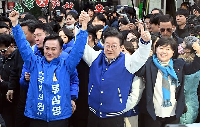 이재명 더불어민주당 상임공동선거대책위원장이 지난 13일 서울 동작구 남성사계시장에서 류삼영 후보와 손을 들어 인사하고 있다. /뉴스1