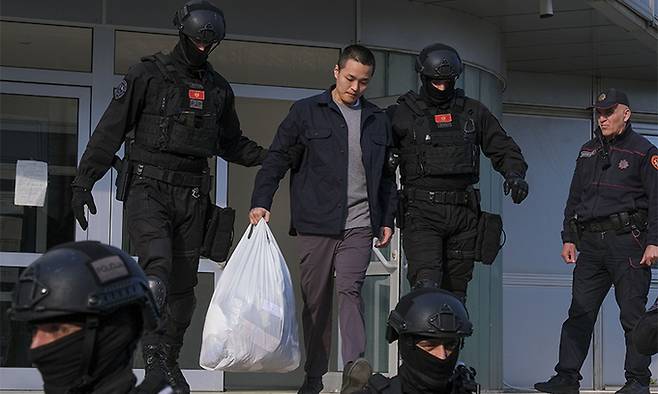 가상화폐 '테라·루나' 사태의 핵심 인물 권도형 테라폼랩스 대표가 지난 23일(현지시간) 몬테네그로 포드고리차의 경찰청에서 조사를 받은 후 경찰관들에게 이끌려 나오고 있다. AP뉴시스