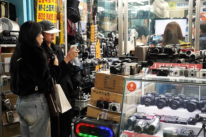 Visitors browse camera lenses and other equipment at a store at the Sewoon Shopping Center, March 21. (Lee Si-jin/The Korea Herald)
