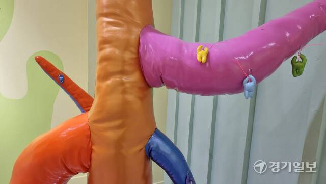 깪 작가의 '아모나무'(2022) 작품 일부와 나무에 걸려 있는 반려인간 '아모'의 모습. 작가는 누군가에게 입양된 작은 아모 귀걸이가 주인의 반려 친구가 될 수 있다는 내용을 담았다. 이나경기자