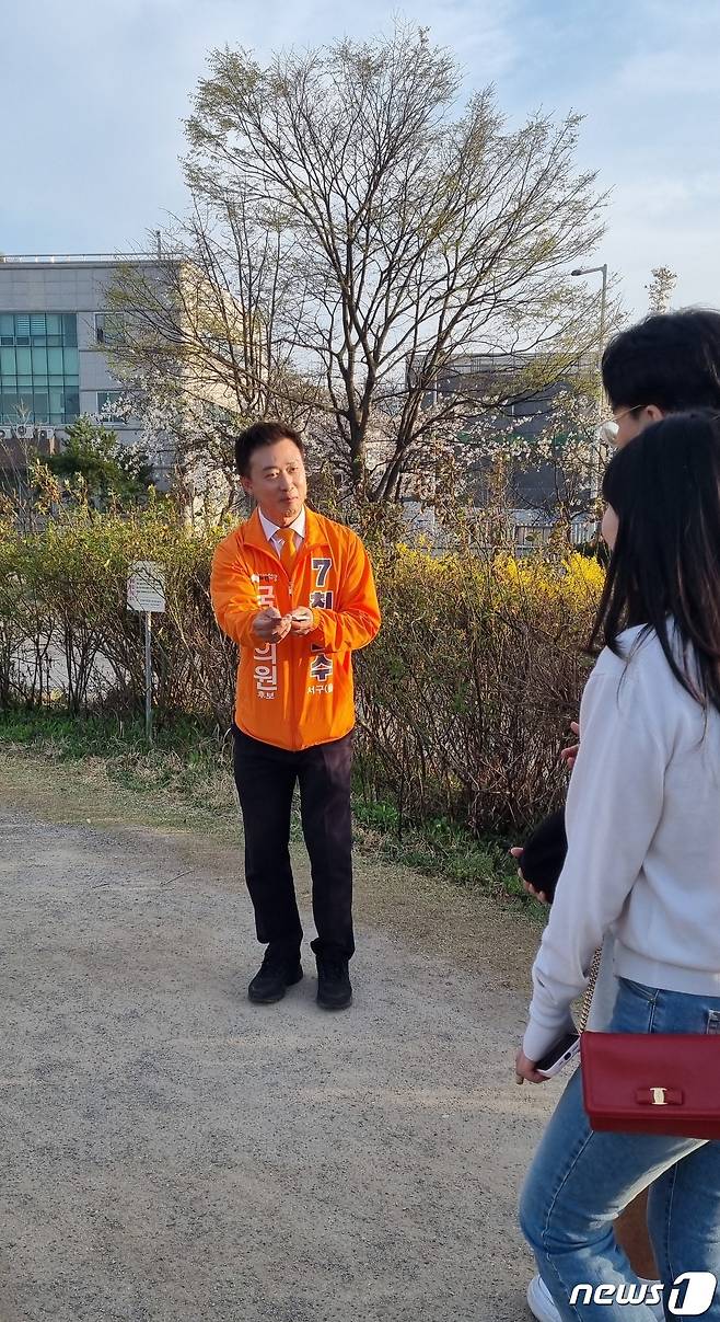 최현수 개혁신당 광주 서구을 후보가 광주 서구 풍암동 풍암저수지에서 산책하는 시민들에 유세하고 있다.(후보측 제공)2024.3.31./뉴스1