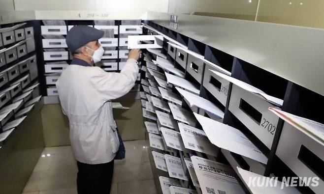 30일 경기도 부천시 상동 한 주상복합건물 우편함에 투입된 제22대 국회의원선거 투표안내문을 입주주민이 자신의 우편함에서 꺼내고 있다.