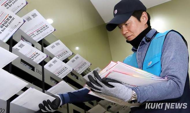 30일 오후 경기 부천시 원미구 상동역 인근 주상복합건물에서 우체국 집배원이 우편수취함에 ‘제22대 총선’투표안내문을 투함하고 있다.