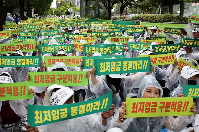 지난달 21일 오후 서울 국회의사당역 인근에서 열린 최저임금 동결 촉구 결의대회에서 소상공인연합회원들이 피켓을 들고 구호를 외치고 있다./연합뉴스