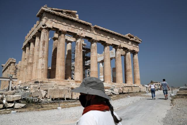 그리스 아테네의 아크로폴리스에 있는 파르테논신전 앞에서 현지 문화부 직원이 마스크를 쓴 채 근무하고 있다. 아테네=로이터 연합뉴스