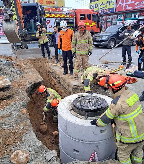 지난 30일 안성시 계동 배수관로 공사 현장에서 흙더미에 매몰된 작업자 1명을 구조하고 있다. [사진=안성소방서]