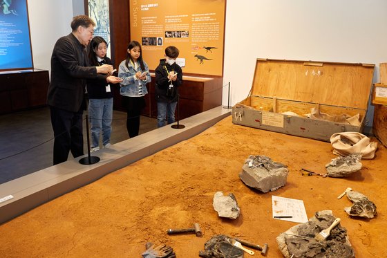 임종덕(맨 왼쪽) 센터장이 백인성 교수 연구팀의 1999년 경남 하동군 공룡 화석 발굴 현장 재현물을 설명하고 있다.