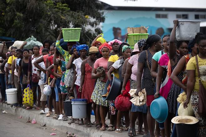 2024년 3월25일 아이티 주민들이 식량과 생필품 등을 구하려 도미니카 국경 지역에 늘어서 있다. EPA 연합뉴스
