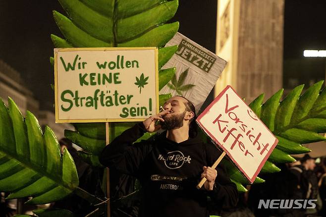 [베를린=AP/뉴시스] 1일(현지시각) 독일 베를린에서 '스모크 인' 행사가 열려 브란덴부르크 게이트 앞에 모인 사람들이 마리화나를 피우고 있다. 독일 정부가 1일부터 대마초를 부분 합법화해 18세 이상 성인은 최대 25g의 대마초를 소지할 수 있게 됐다. 2024.04.02.