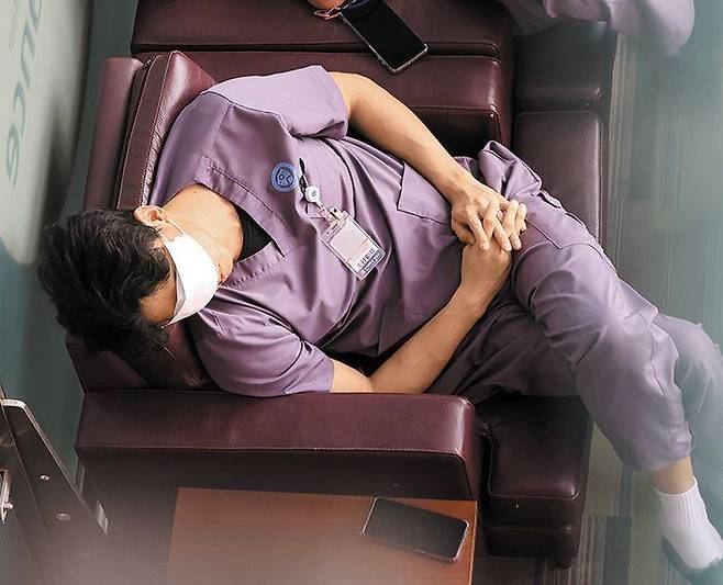 전공의 이탈 1주일… 그래도 병원을 지키는 사람들 - 2월 26일 서울 시내에 있는 대학병원에서 의료진 한 명이 소파에 앉아 잠시 휴식을 취하고 있는 모습. 보건복지부에 따르면, 주요 병원 100곳의 전공의 1만2000여 명 중 1만명 이상이 사직서를 제출(23일 기준)한 상태다. 이에 남아있는 의료진에게 업무가 가중되고 있다. /연합뉴스