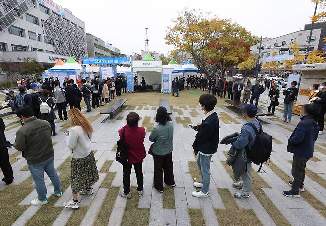 지난 11월 4일 오후 서울 강동구청 앞 잔디광장에서 열린 2021 강동 취업박람회에서 구직자들이 입장을 위해 줄을 서고 있다. 이날 취업박람회는 코로나19 확산 방지를 위해 행사장에 99명까지 입장을 제한했다. 2021.11.4 /연합뉴스