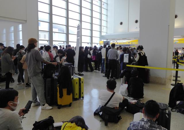 일본 오키나와현 나하공항을 찾은 여행객들이 3일 쓰나미(해일) 경보 발령으로 공항 운영이 중단되자 공항 안에서 대기하고 있다. 오키나와=EPA 연합뉴스