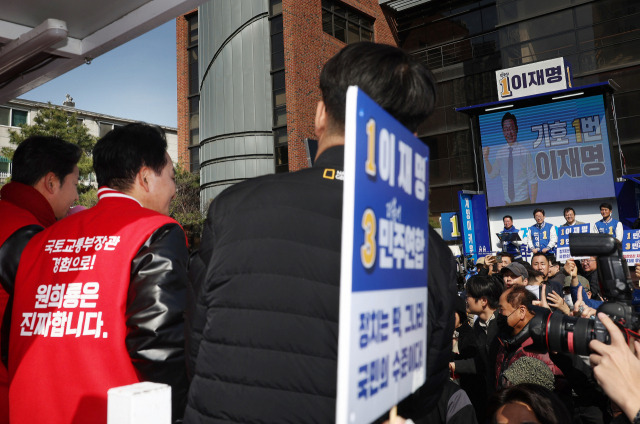 ▲인천 계양을에 출마한 국민의힘 원희룡 후보가 지난달 31일 계양구 서운성당 앞에서 선거 유세를 하던 더불어민주당 이재명 대표 앞을 유세차를 타고 지나고 있다. ⓒ연합뉴스
