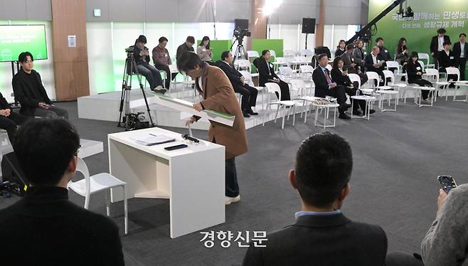 윤석열 대통령이 지난 1월 22일 서울 동대문구 한국콘텐츠진흥원 콘텐츠인재캠퍼스에서 예정된 ‘국민과 함께하는 민생토론회 - 다섯 번째, 생활규제 개혁’에 불참하기로 알려지자 관계자가 윤 대통령 자리를 정리하고 있다. 대통령실사진기자단