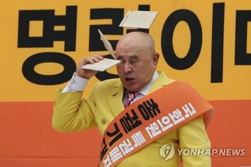 국회의원 특권은 이렇게 깨트리는 것입니다.  2023년 7월17일 제헌절 오후 서울 여의도 국회의사당 앞에서 열린 국회의원 특권 폐지 촉구 집회에서 87세의 원로 액션배우 조춘 씨가 머리로 송판을 깨는 퍼포먼스를 하고 있다.
