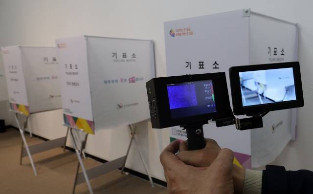 제22대 총선 사전투표를 하루 앞둔 4일 오후 대전시 서구 둔산동 대전시청 전시실에 마련된 사전투표소에서 선관위 관계자들이 불법 카메라 설치 여부를 확인하고 있다. 연합뉴스