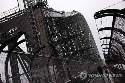 지난 4일 관광객이 우산을 들고 호주 시드니 하버 브리지에 오르고 있다. AFP 연합뉴스