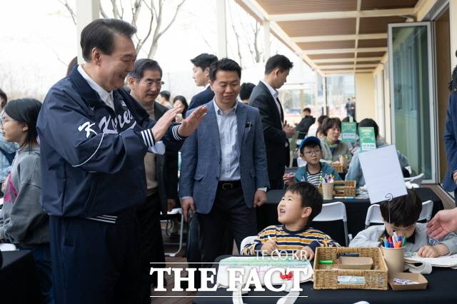윤석열 대통령이 6일 오후 서울 용산어린이정원을 방문해 분수정원 잼잼카페에서 열린 에코백 만들기 프로그램을 참관하고 있다. 대통령실은 윤 대통령이 용산어린이정원 개방 이후 자주 이곳을 찾아와 시민들과 소통해왔다고 강조했다. /대통령실 제공