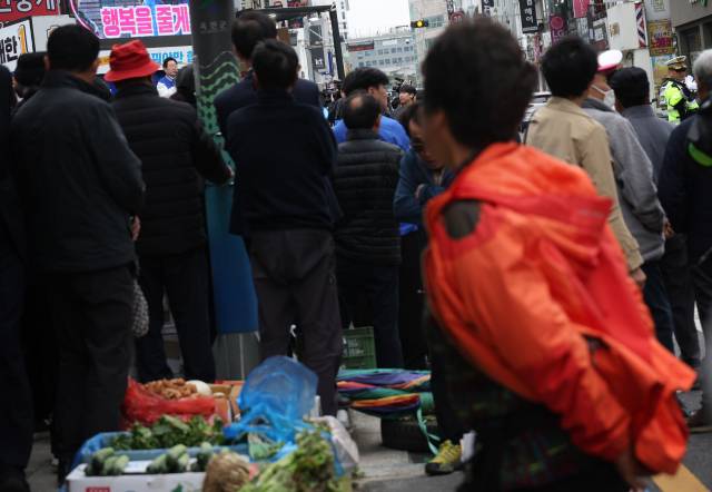 ▲한 상인이 더불어민주당 이재명 대표의 이재한 후보 지원 유세를 듣고 있다. ⓒ연합뉴스