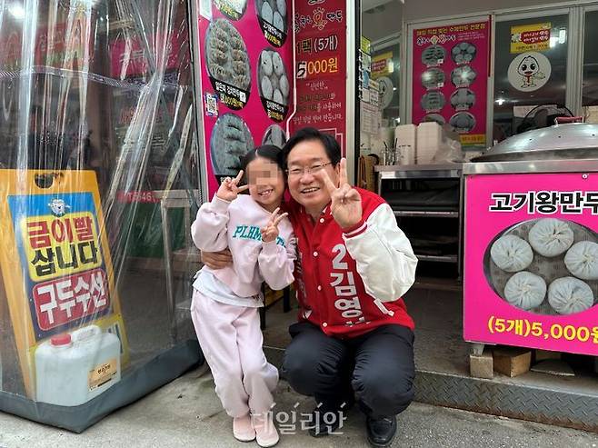 충남 아산갑 지역구에 출마하는 김영석 국민의힘 후보가 6일 온양온천시장을 방문해 시민들에게 인사하던 중 한 아이와 기념사진을 촬영하고 있다. ⓒ데일리안 강현태 기자