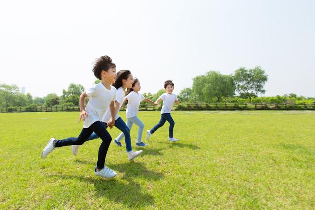 어린이들이 푸른 잔디밭에서 달리기를 하고 있다. 게티이미지뱅크