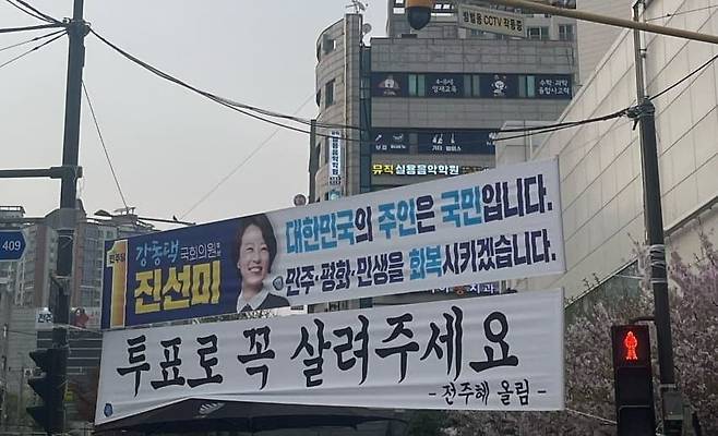서울 강동갑 지역구인 명일역사거리 인근에 전주혜 국민의힘 후보와 진선미 더불어민주당 후보 측의 현수막이 걸려있는 모습/ 온라인 커뮤니티 캡쳐