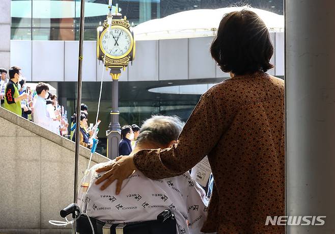 [서울=뉴시스] 김근수 기자 = 정부와 의사 간 갈등이 장기화되고 있는 1일 서울 서대문구 신촌 세브란스 병원 앞에서 한 입원 환자가 서울지역 전공의 수련병원 노동조합 대표자 합동 기자회견을 바라보고 있다. 2024.04.01. ks@newsis.com