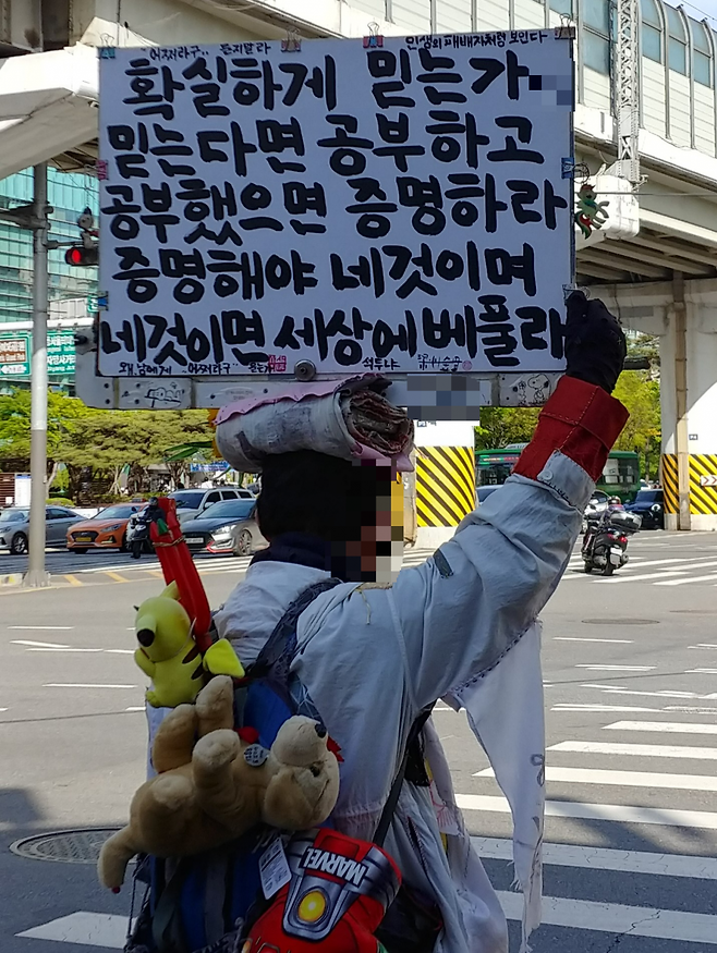 팻말 구석에 보일듯 말듯 적힌 이름 석 자로 그의 정체를 짐작해볼 뿐이다.