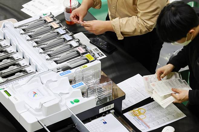 9일 오후 광주 서구 빛고을체육관에 설치된 개표소에서 개표사무원들이 투표지분류기 모의시험을 하고 있다. 연합뉴스