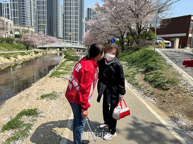 '충남 정치 1번지' 천안갑 지역구에 출마하는 신범철 국민의힘 후보 배우자 정혜진(51)씨가 9일 원성천 일대 쓰레기를 수거하던 중 시민에게 격려 인사를 받고 있다. ⓒ데일리안 강현태 기자