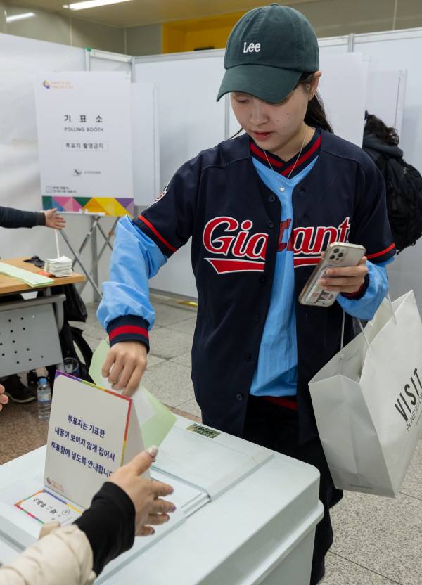제22대 국회의원선거날인 10일 동래구 사직역에 마련된 투표소에서 롯데 자이언츠 경기를 관람하러 온 유권자가 투표를 하고 있다. / 이원준 기자windstorm@