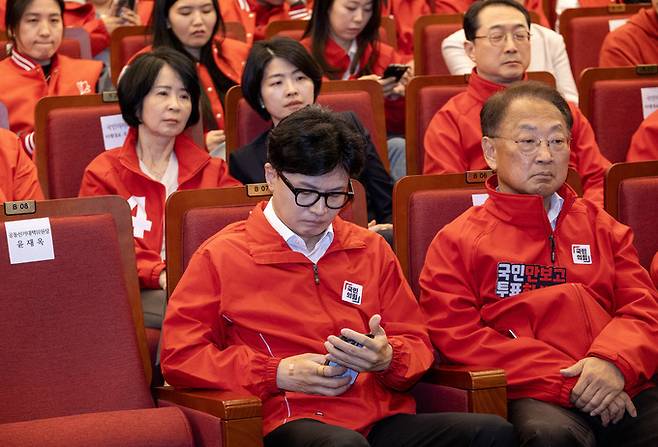 한동훈 국민의힘 비대위원장이 10일 오후 서울 여의도 국회도서관에 마련된 개표상황실에서 방송사 출구조사 결과 발표가 끝난 뒤 휴대폰을 바라보고 있다.    공동취재