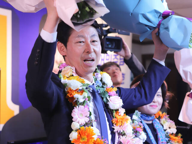 제22대 국회의원 선거 인천 남동구을에 출마한 더불어민주당 이훈기 후보가 당선을 확정한 뒤 꽃다발을 들고 환호하고 있다. 이인엽기자