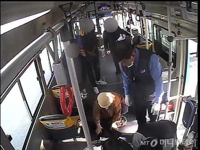 지난 4일 부산 200번 버스에서 심정지로 쓰러진 80대 남성 A씨에게 응급처를 하는 시민들의 모습./사진=세익여객