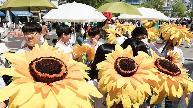 제2회 '노원 차 없는 거리' 행사가 열린 서울 노원역 일대에서 학생들이 모형 해바라기꽃을 들고서 플래시몹 공연 준비를 하고 있다. 연합뉴스