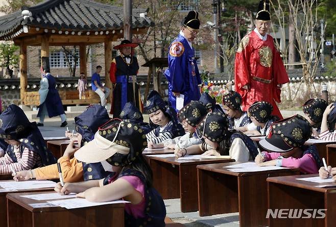 [서울=뉴시스] 최동준 기자 = 13일 서울 강남구 못골한옥어린이도서관에서 유생복장을 한 어린이들이 과거시험 방식으로 독서경연을 하고 있다. 2024.04.13. photocdj@newsis.com