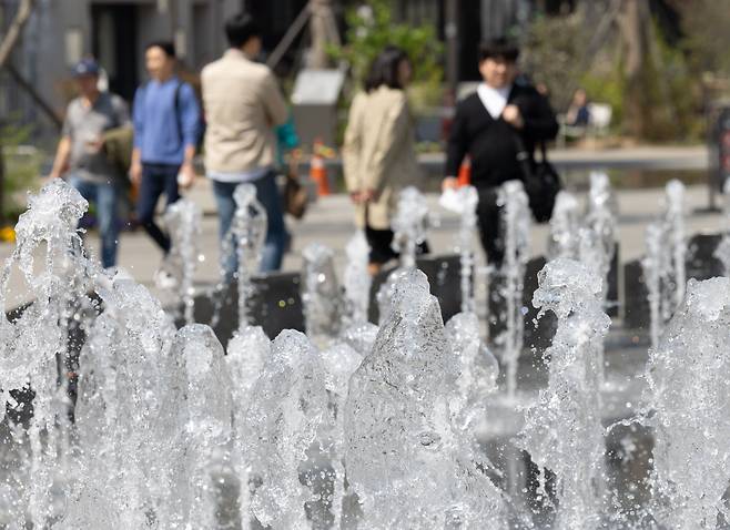 서울 낮 기온이 23도까지 오른 지난 12일 오후 서울 세종대로 광화문광장 분수대에서 시민들이 길을 거닐고 있다. /뉴스1