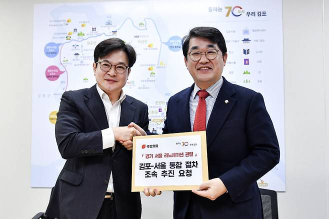 김병수 김포시장이 지난 2월 15일 오전 배준영 국민의힘 경기-서울 리노베이션 태스크포스(TF) 위원장에게 서울 편입 절차의 조속한 추진을 요청하는 건의문을 전달하고 있다. 연합뉴스