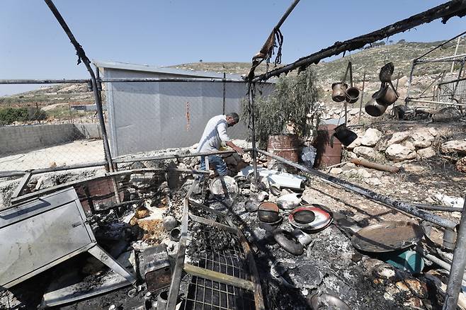 13일(현지시간) 한 팔레스타인 남성이 요르단강 서안지구 알무가이르 마을에서 벌어진 이스라엘 정착촌 주민과의 무력 공격에 대한 피해를 조사하고 있다. EPA연합뉴스