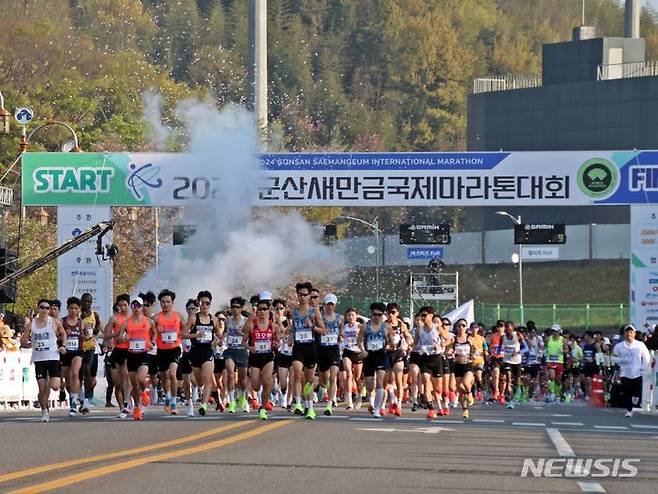 [군산=뉴시스] 고석중 기자 = 14일 오전 전북특별자치도 군산새만금국제마라톤대회에 출전한 엘리트선수단이 월명종합경기장에서 힘차게 출발하고 있다. 이번 대회는 파리 올림픽 국가대표 선발전을 겸해 열려 마라토너들 간의 치열한 각축전이 벌어졌다. 2024.04.14. k9900@newsis.com