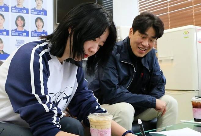 사인하는 강소휘의 곁에서 한국도로공사 김종민 감독이 흐뭇한 미소를 짓고 있다, 한국도로공사