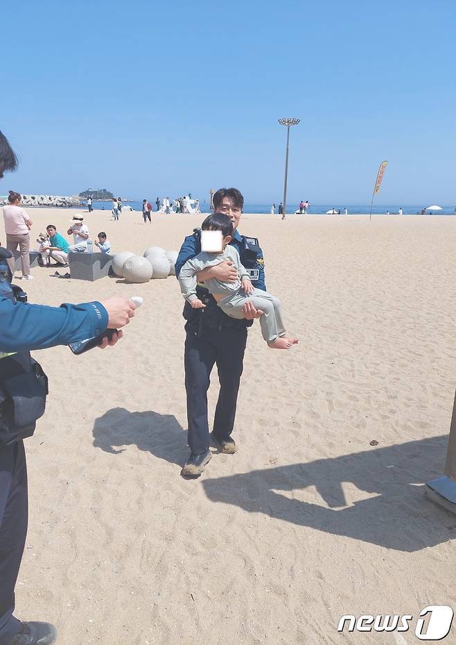 아이 안고 나오는 속초경찰서 청초지구대 고명윤 순경.(속초경찰서 제공)