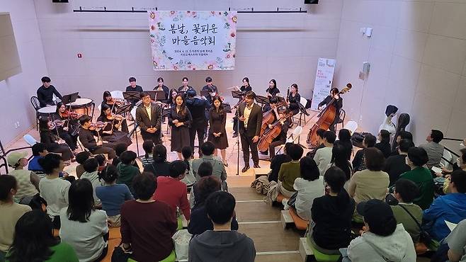 많은 사람들이 오케스트라 공연을 즐기기 위해 모였다.